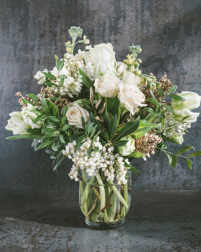 Sympathy arrangement of white roses and greenery